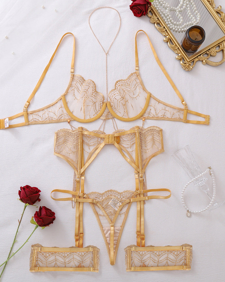 Flat lay of luxury champagne lingerie featuring underwire bra, suspender waist piece and matching garters.