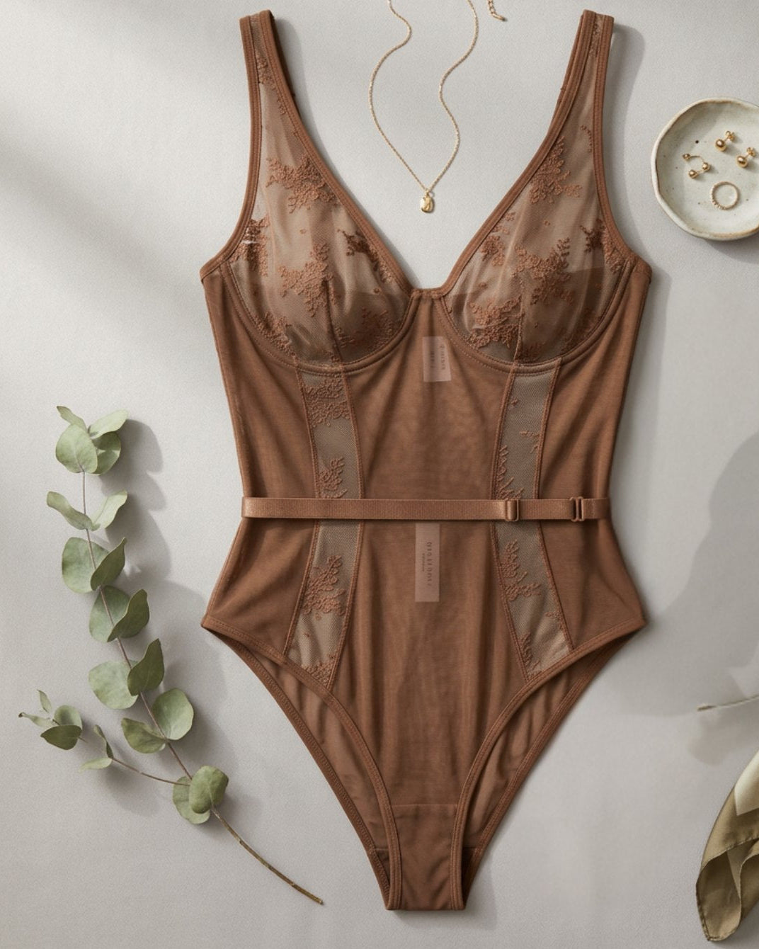 Brown lace lingerie bodysuit with contouring panel construction and supportive underwire cups.