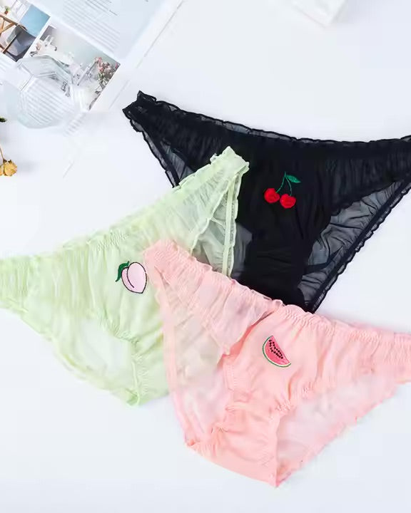 Three pairs of women's underwear with fruit designs on a white surface.